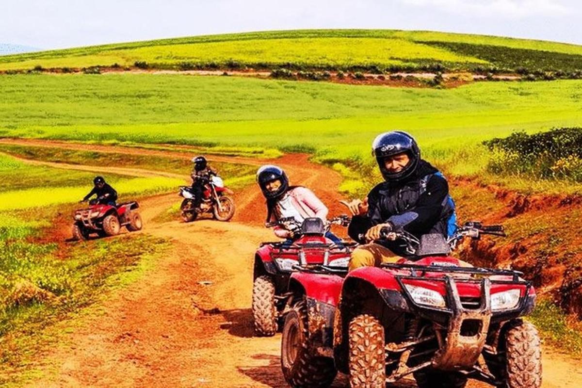 Tres personas viajando en vehículos todo terreno por un camino de tierra