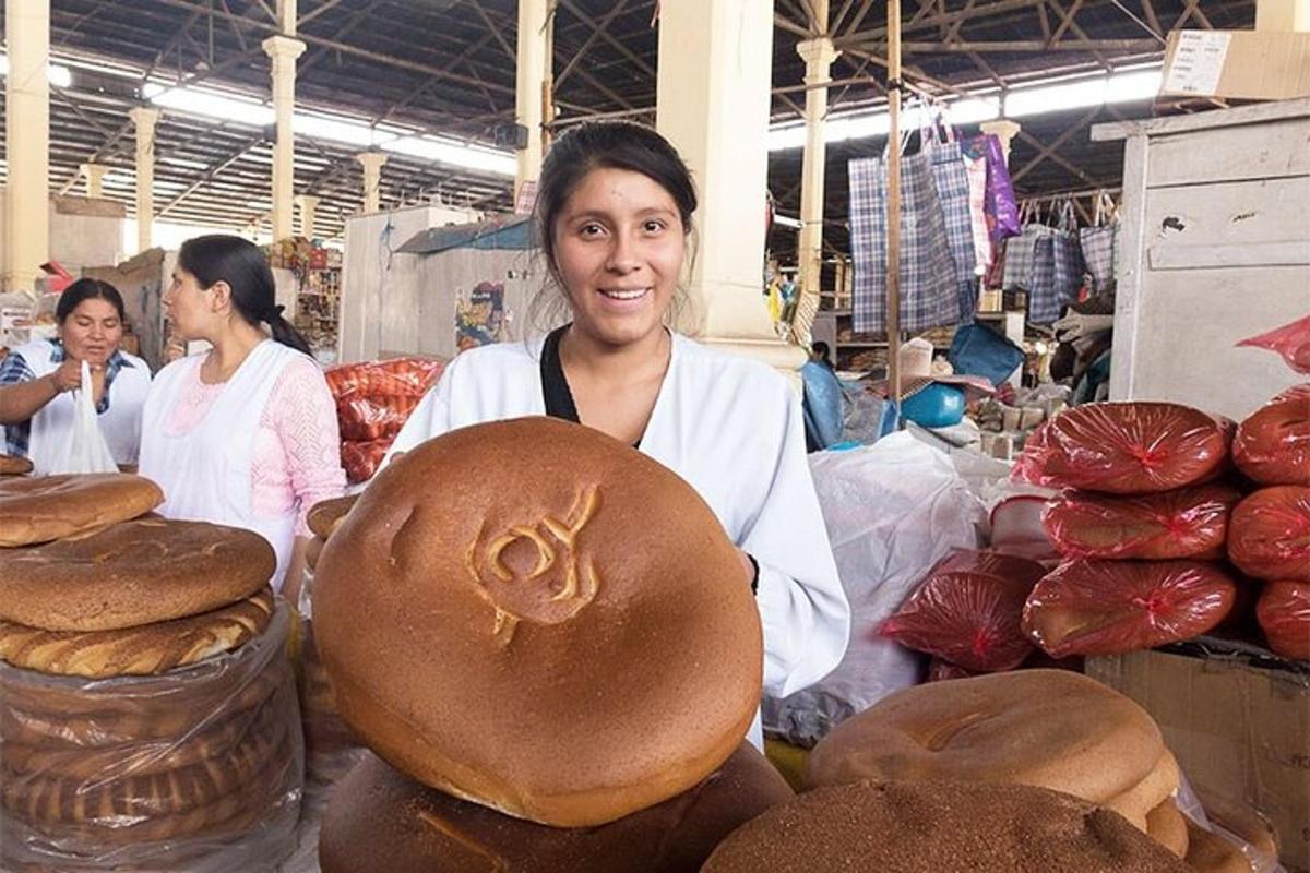 una mujer parada junto a una pila de pan