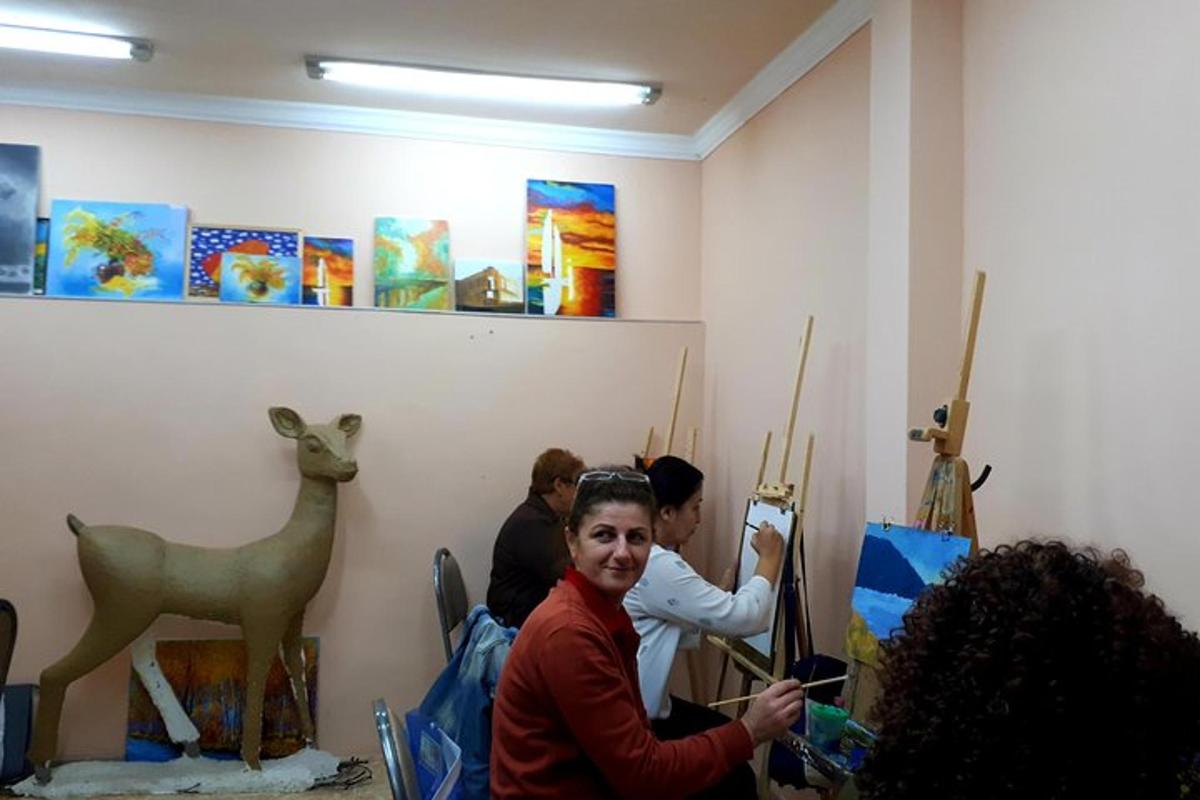 Un grupo de personas de pie en una habitación con pinturas.