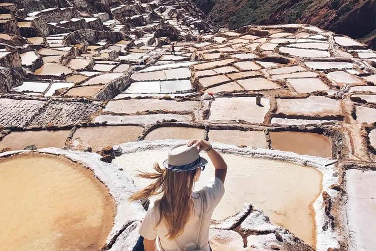 一位戴着帽子的女人坐在山顶上