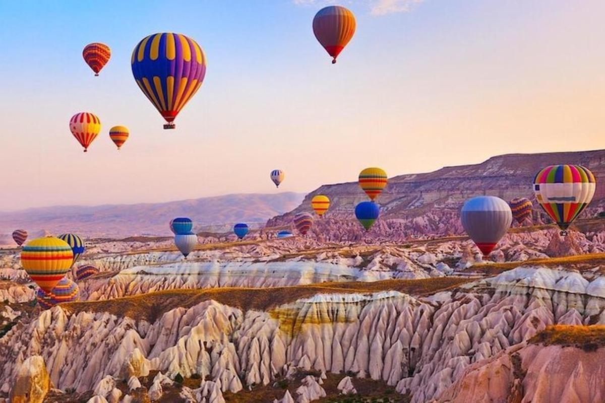 un gruppo di mongolfiere che volano sopra le rocce