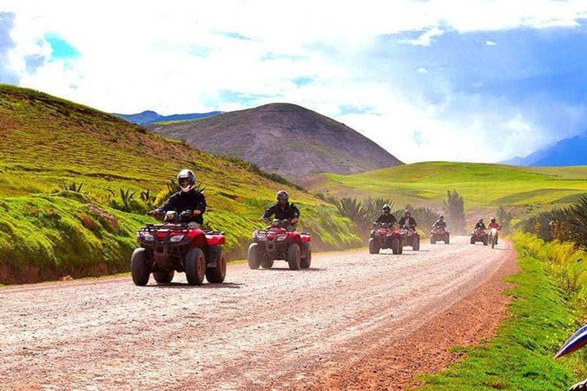 un grup de persones que condueixen quads per un camí de terra