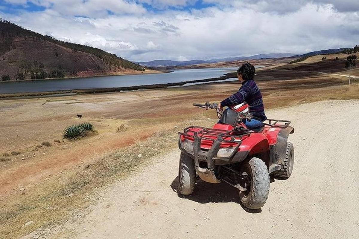 un noi jove que condueix un quad per un camí de terra