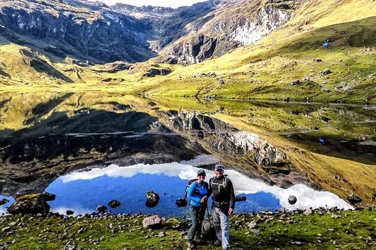 Tveir menn standa fyrir framan fjallavatn