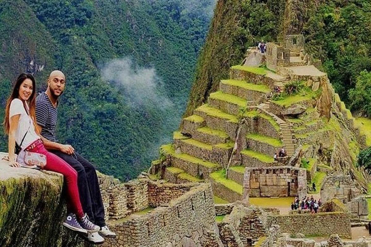 Un hombre y una mujer sentados en el borde de una montaña