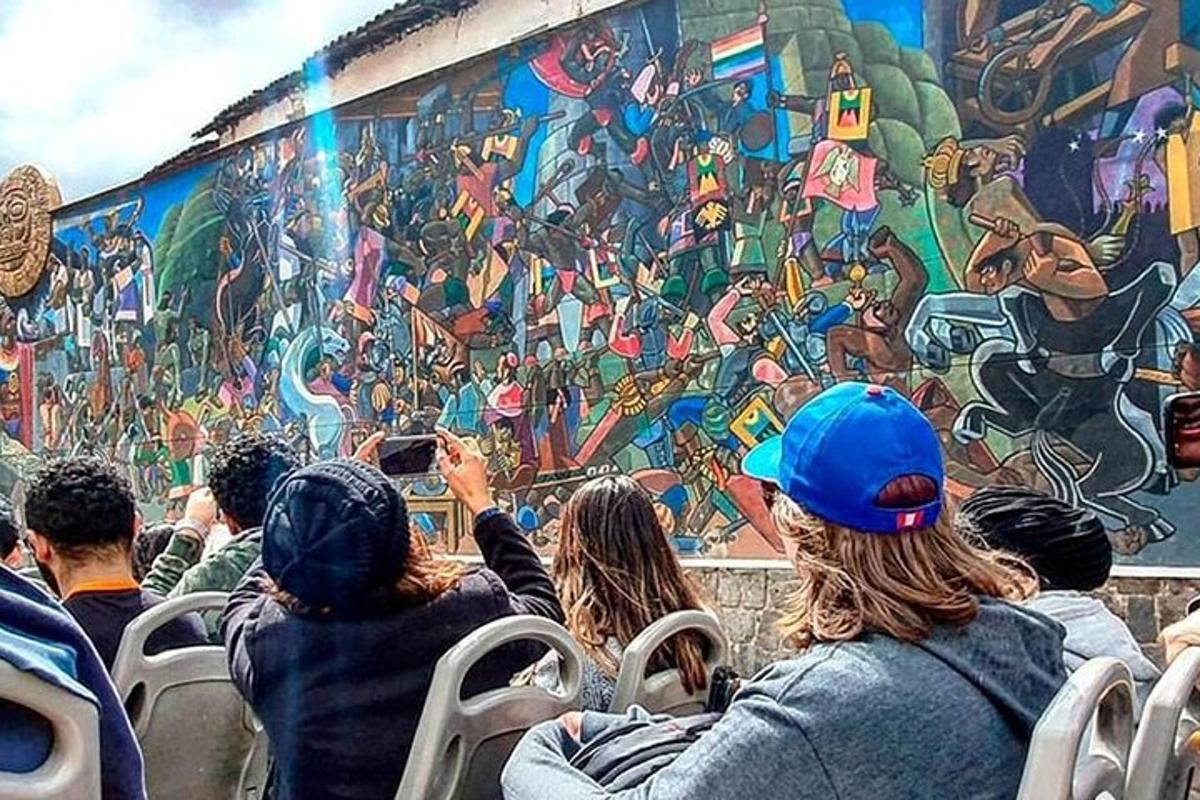 sekumpulan orang duduk di hadapan mural