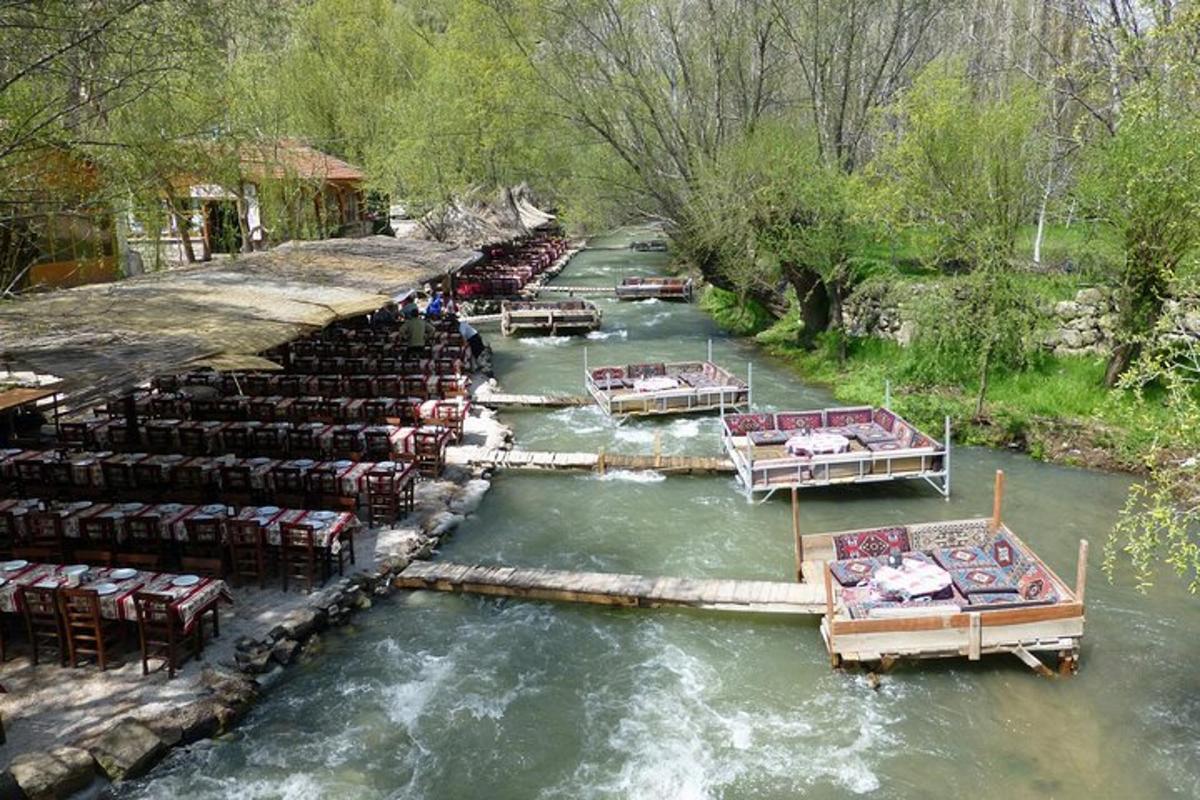 un gruppo di barche in un fiume con tavoli e sedie