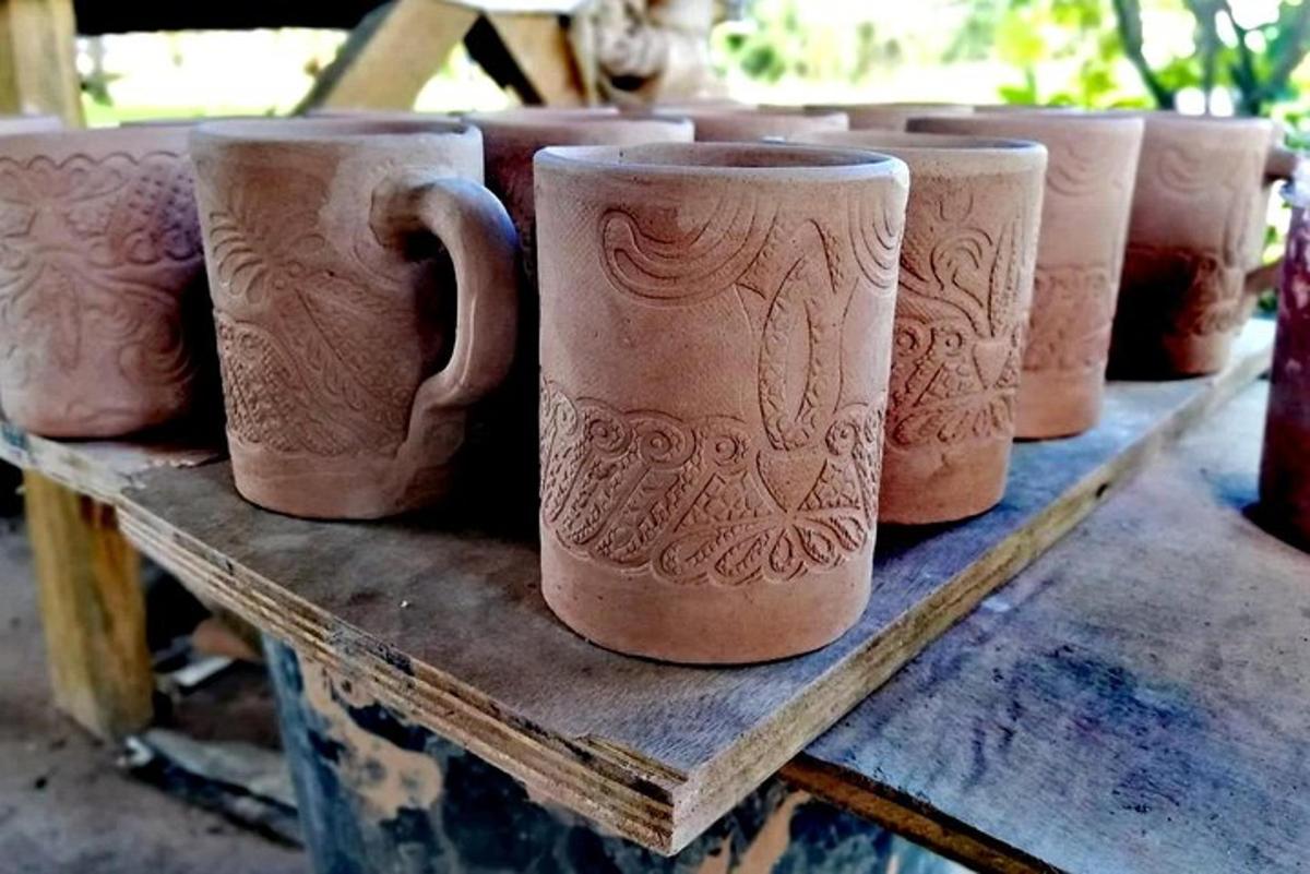 a row of clay cups sitting on a wooden table