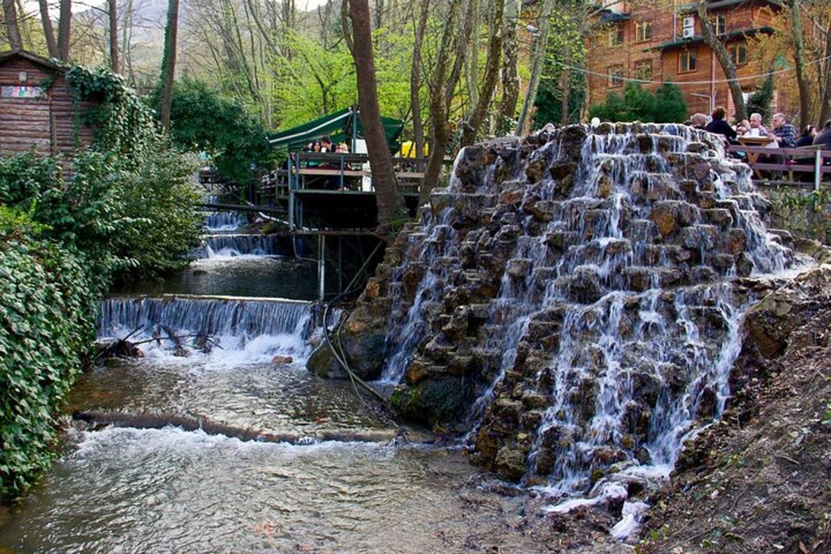 air terjun di taman dengan orang-orang duduk di bangku