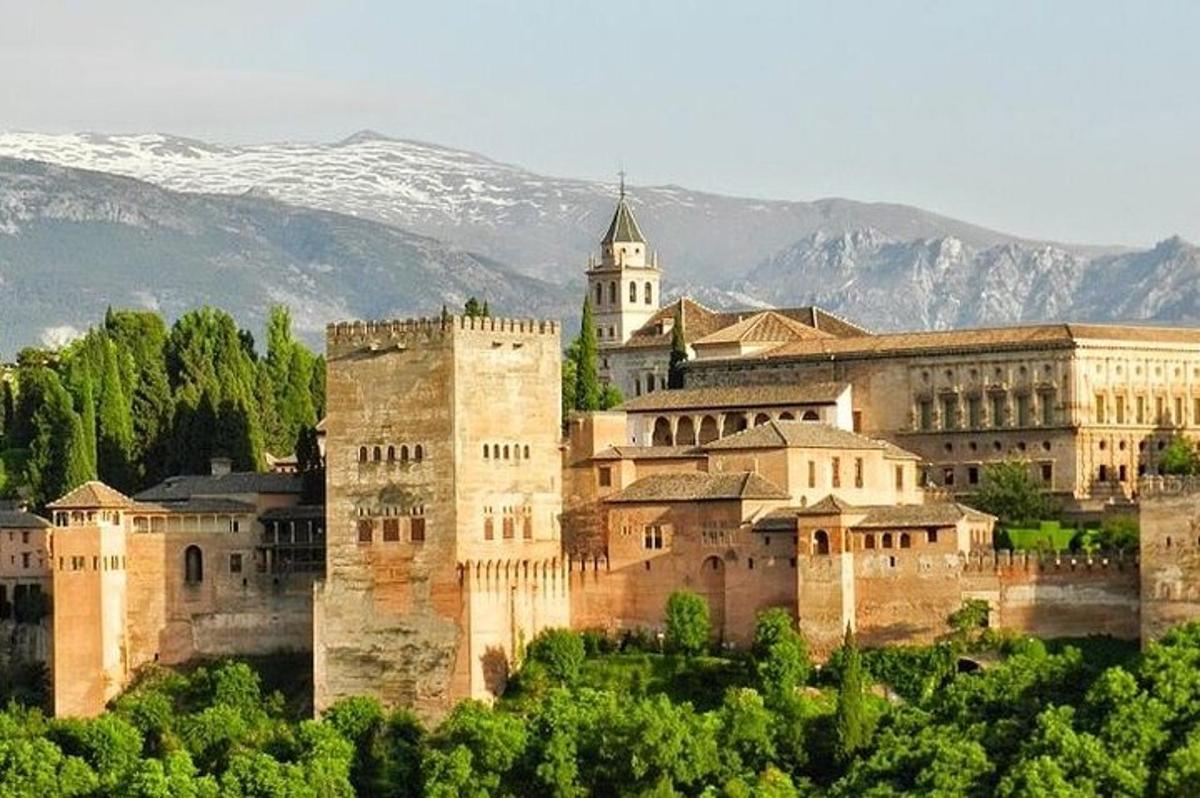 a large building on a hill with mountains in the background