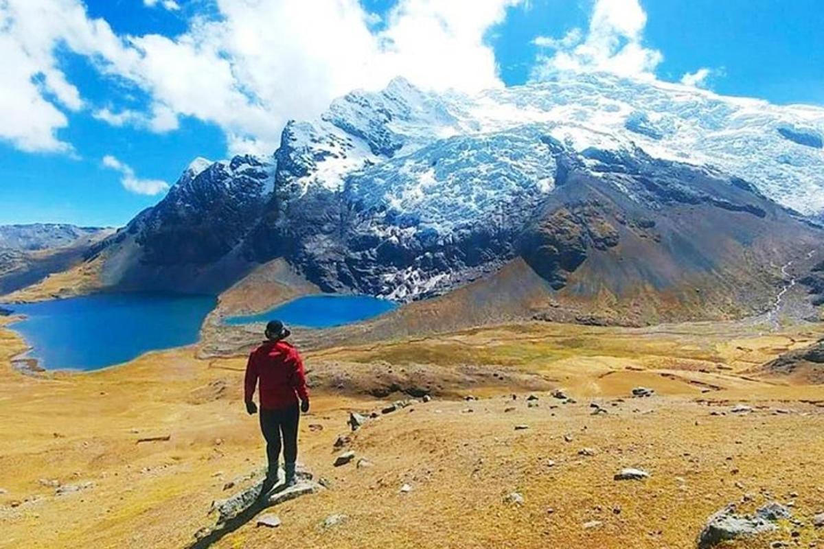 un uomo in piedi su una collina che guarda una montagna