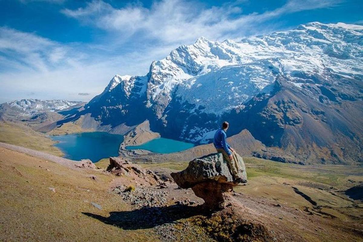 un uomo seduto su una roccia in cima a una montagna