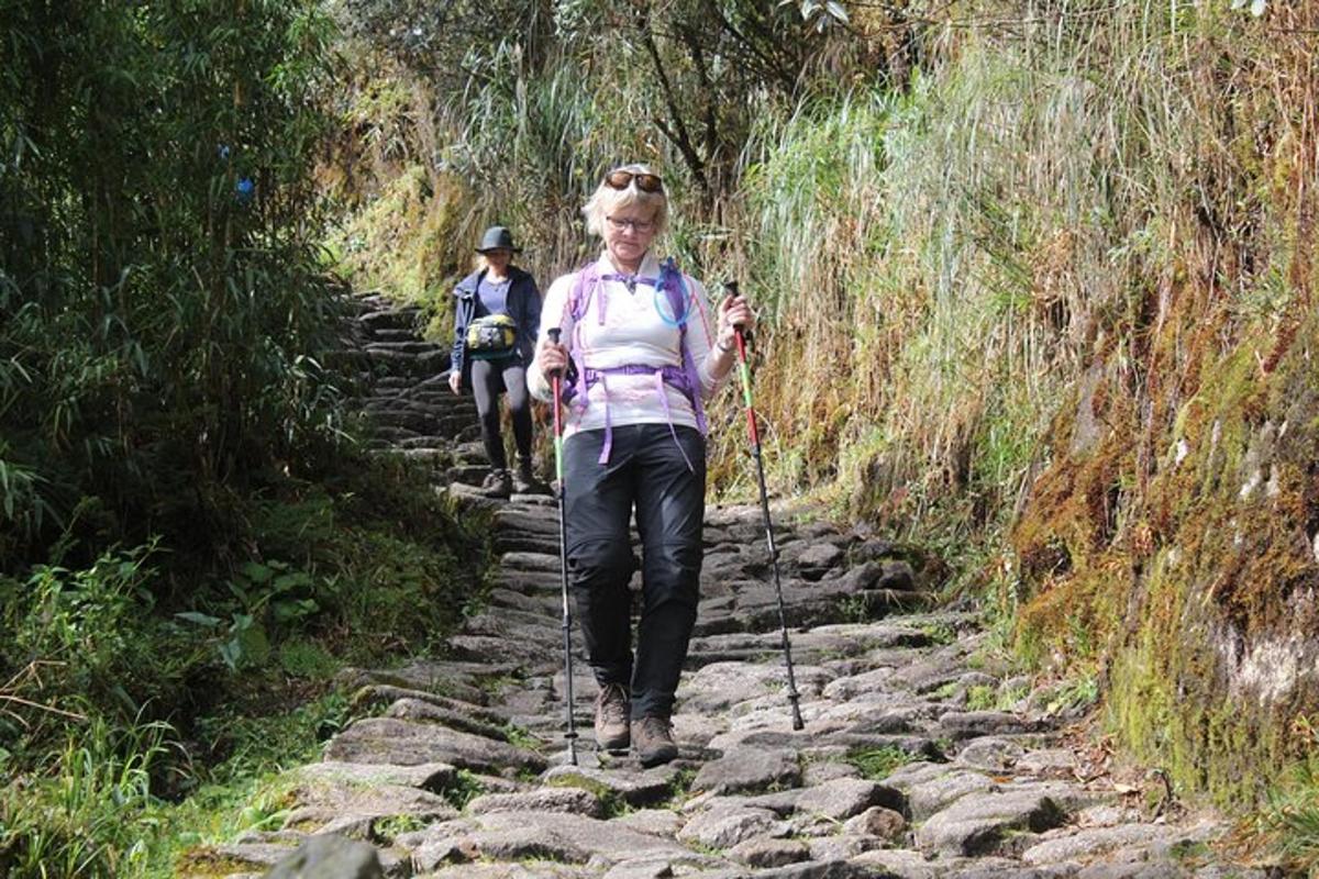 a woman walking down a trail on some rocks
