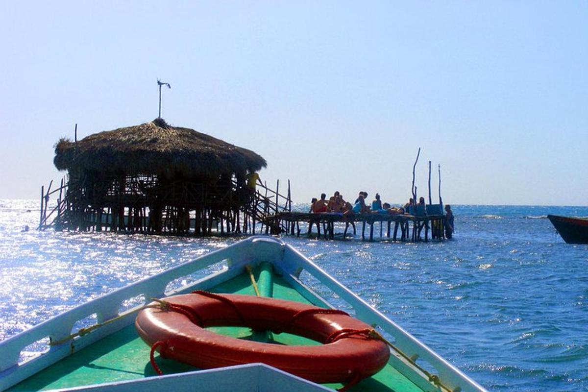 isang bangka na may balsa sa tubig na may pier