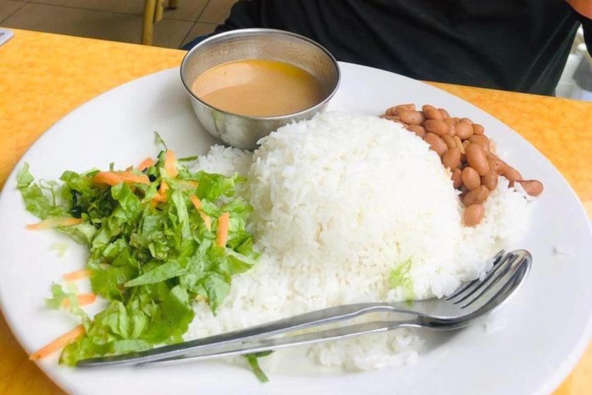 un piatto di riso e verdure e una ciotola di salsa