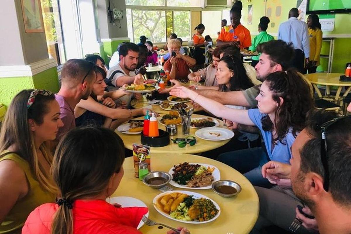 un gruppo di persone sedute ai tavoli che mangiano cibo