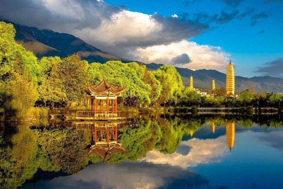 a reflection of a pagoda in the water of a lake