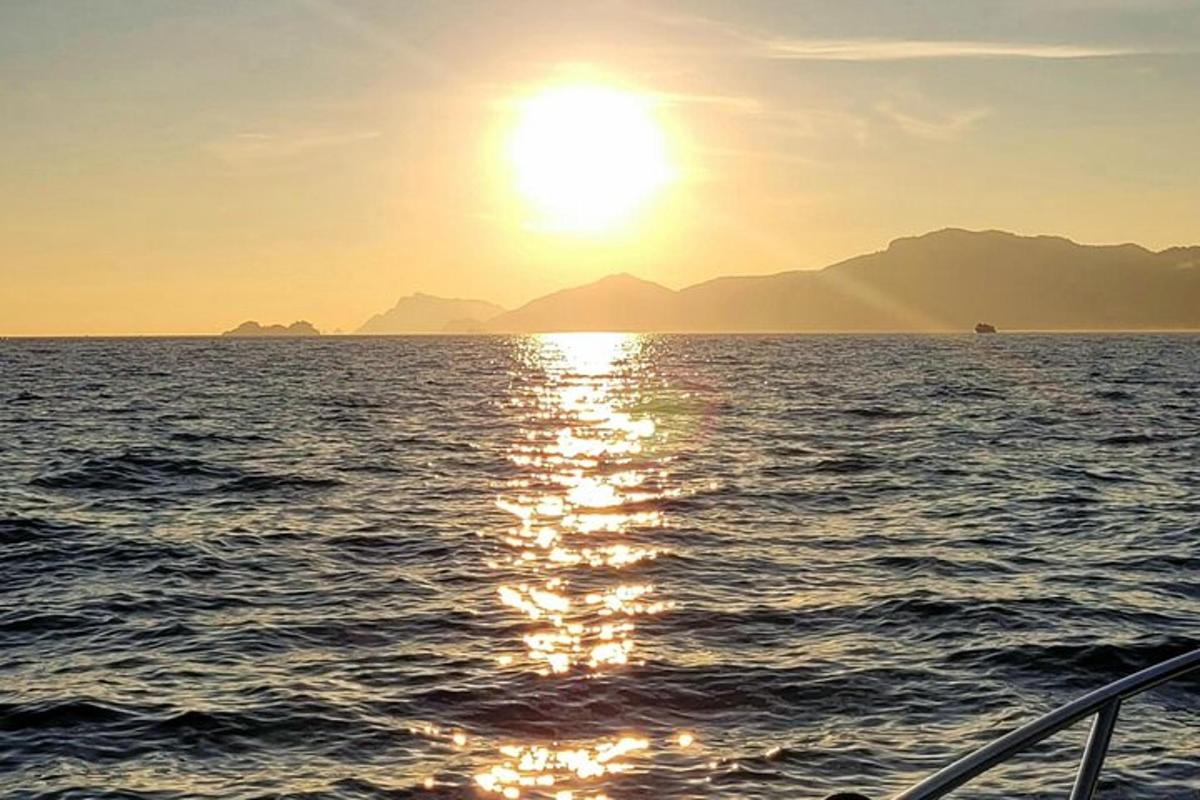 egy hajó az óceánon a lenyugvó nappal