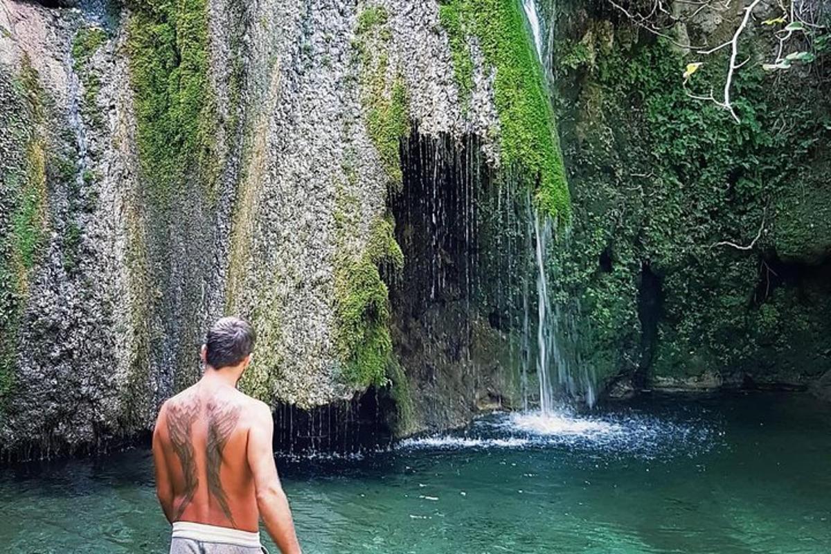 човек стоји испред водопада