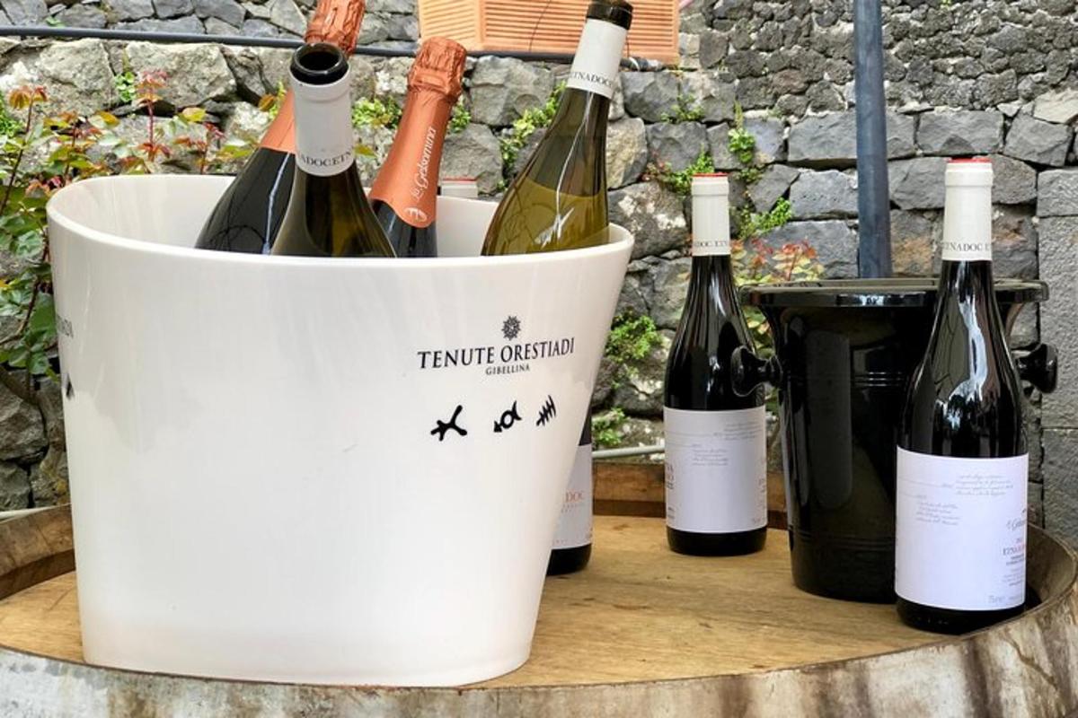 tre bottiglie di vino in un secchio su una botte