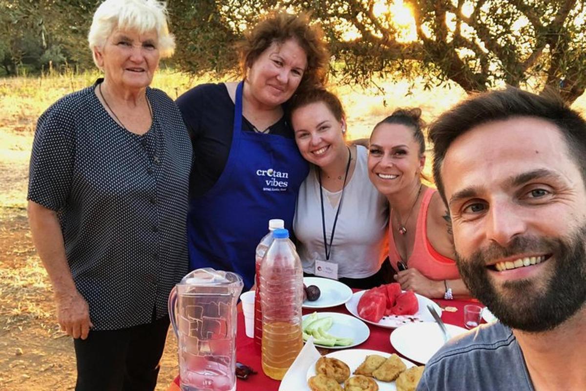 μια ομάδα ανθρώπων που στέκονται γύρω από ένα τραπέζι με φαγητό