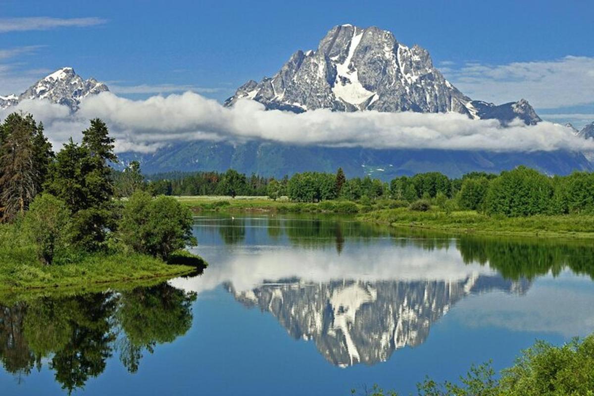 un riflesso di montagna in un fiume con una montagna