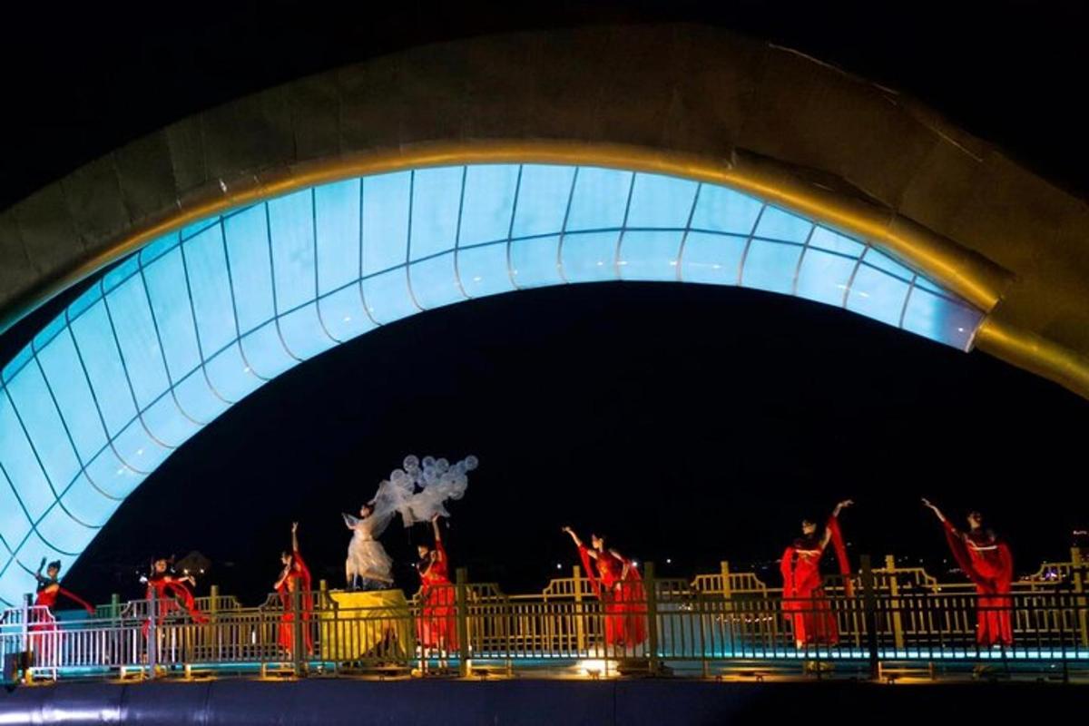 a group of people dancing under a bridge