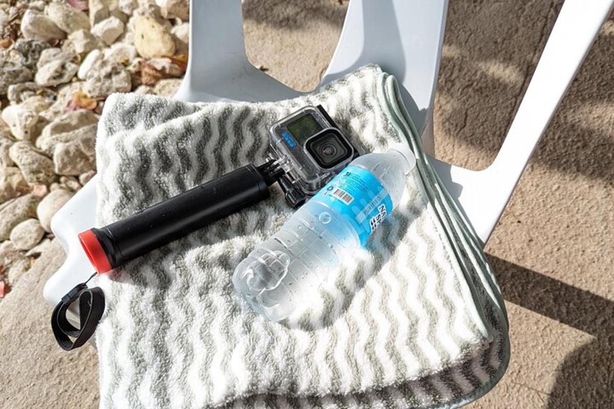 eine Kamera und eine Flasche Wasser in einer Handtasche