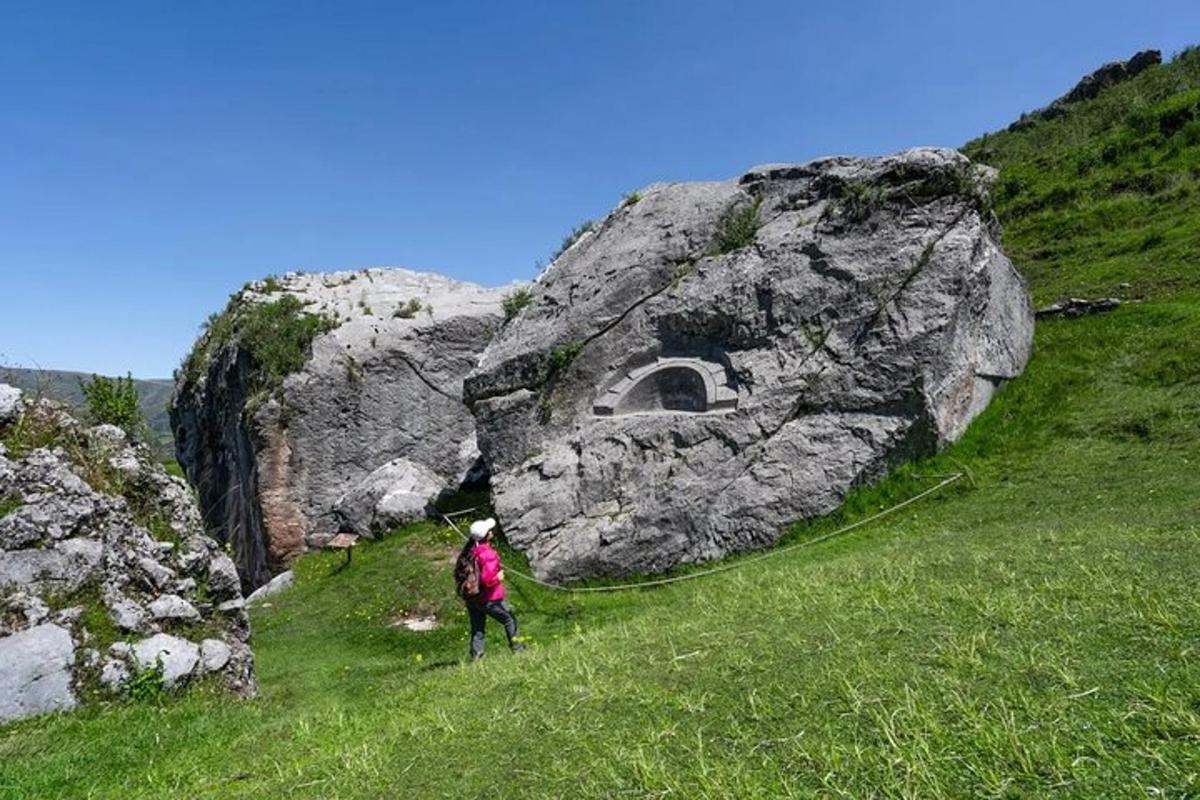 особа која стоји испред велике стене