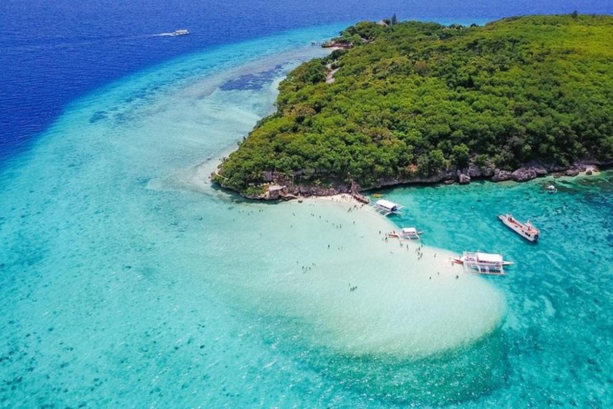 eine Insel im Ozean mit Booten im Wasser