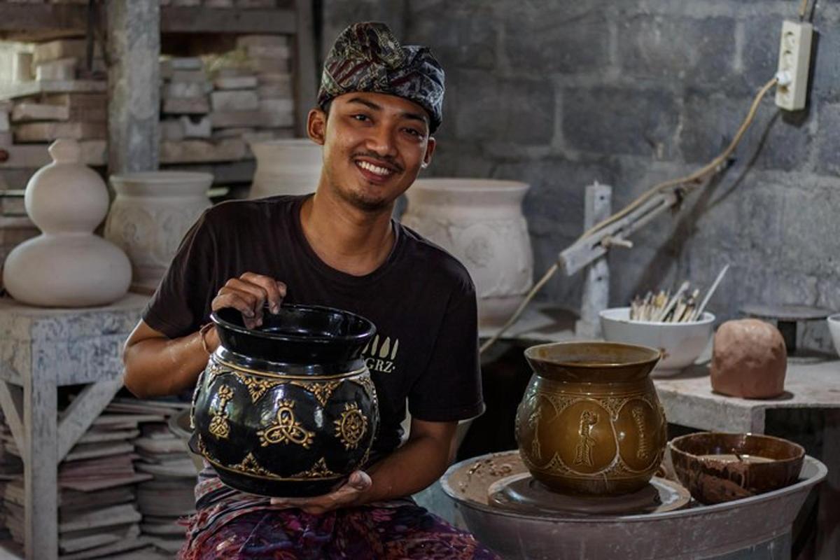 a man holding a pot on top of a table