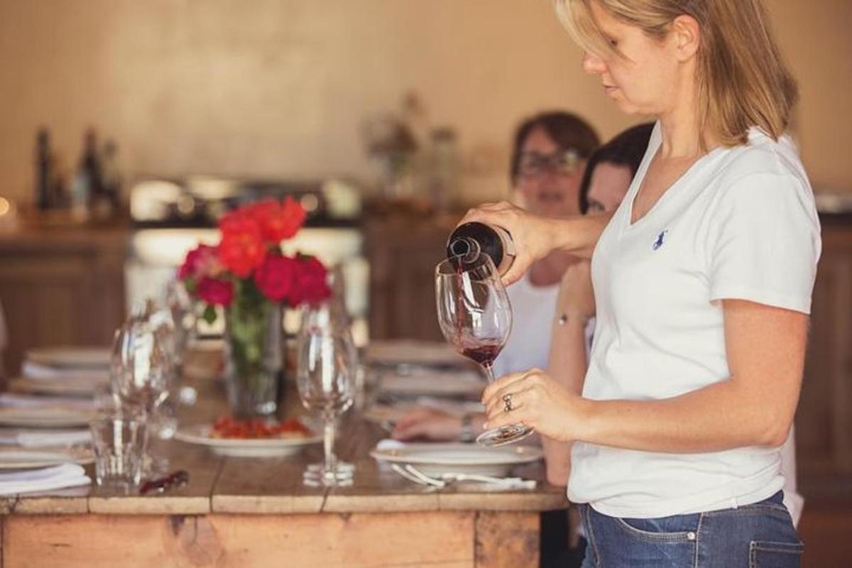 una donna che versa un bicchiere di vino a un tavolo