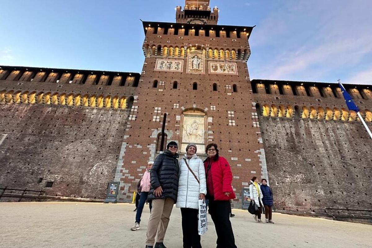 Un grupo de personas de pie frente a una torre de reloj.