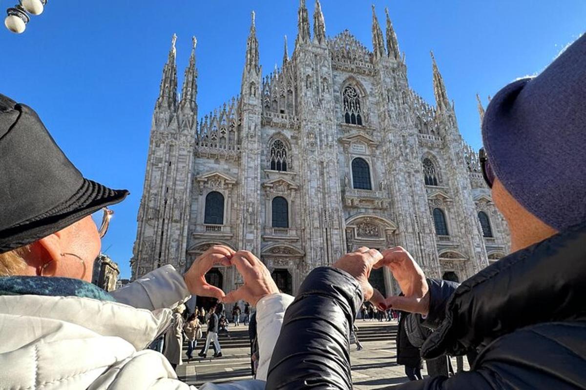 Dos personas levantando las manos frente a una catedral.