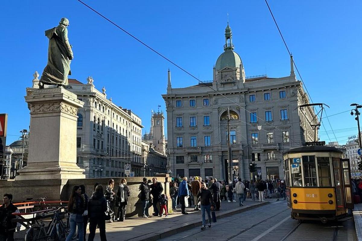 un gruppo di persone che camminano in una città con una statua