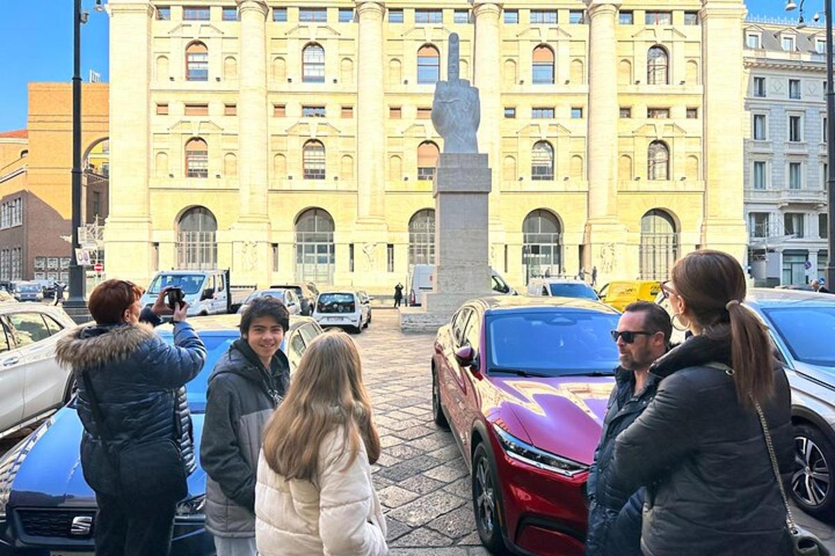 un gruppo di persone in piedi davanti alle auto