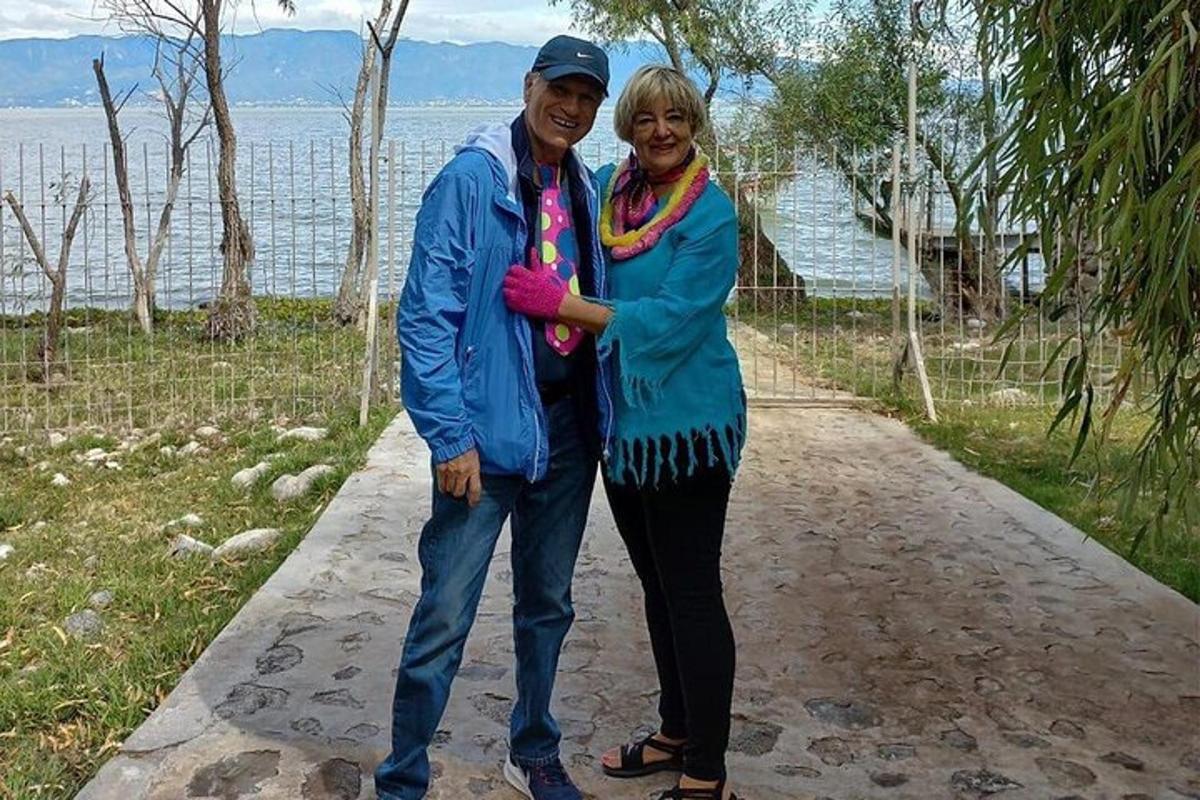Un hombre y una mujer de pie en un sendero cerca del agua.
