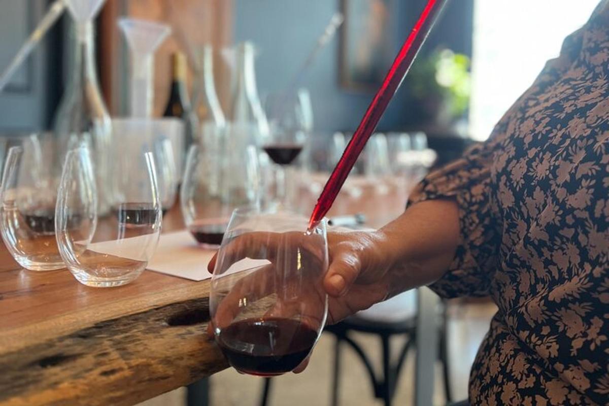 a woman is holding a glass of red wine