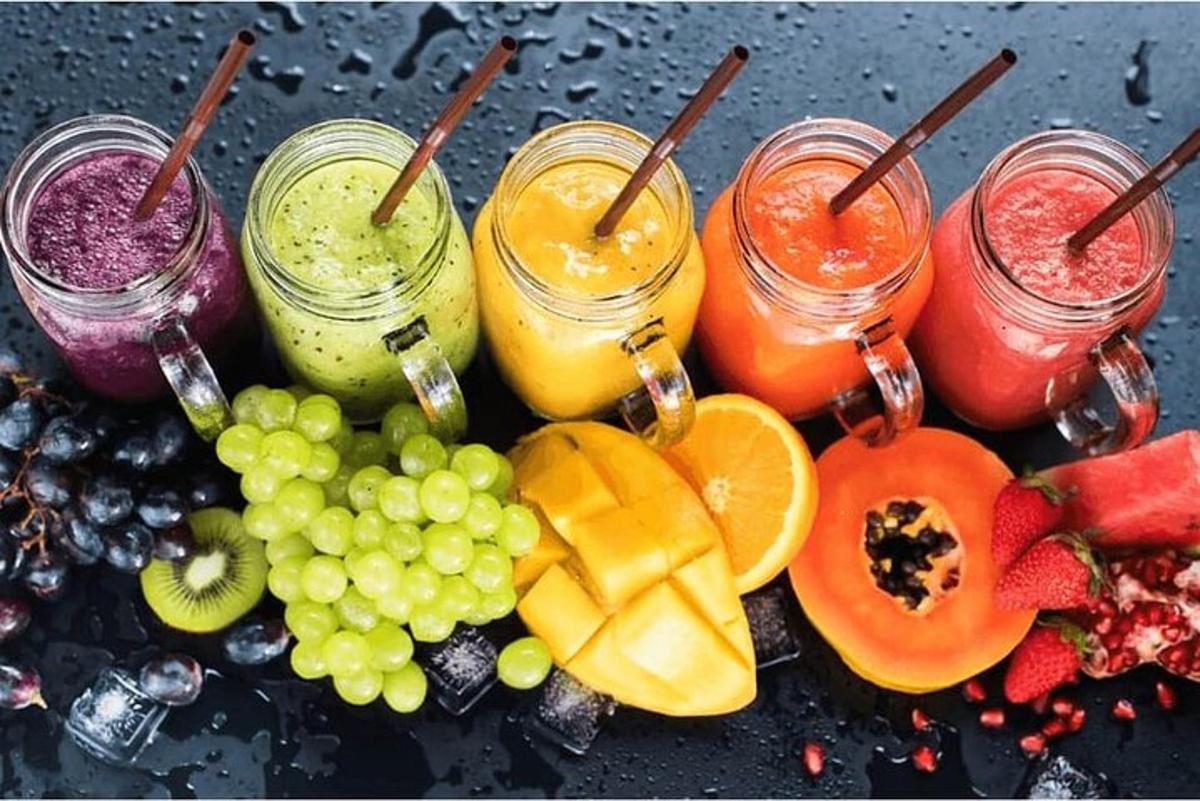 un mucchio di frutta diversa e barattoli di succo