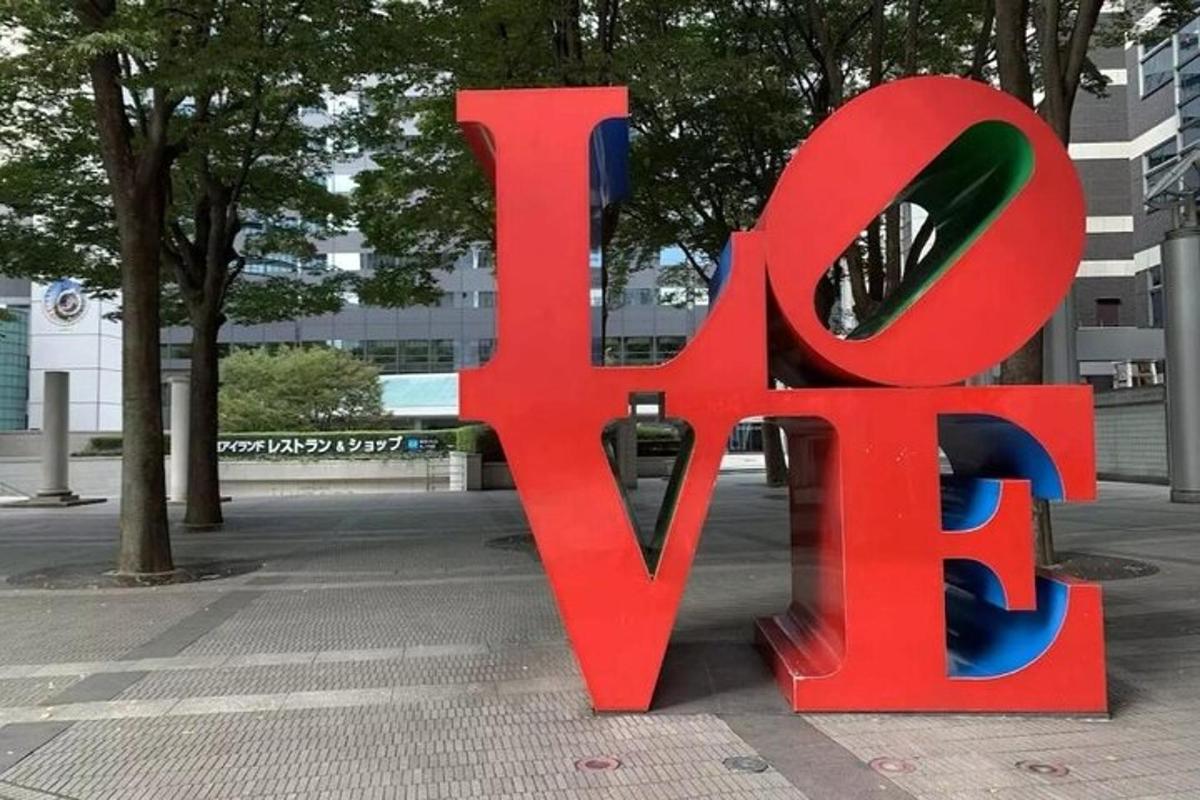 Un gran cartel rojo que dice amor en una acera.