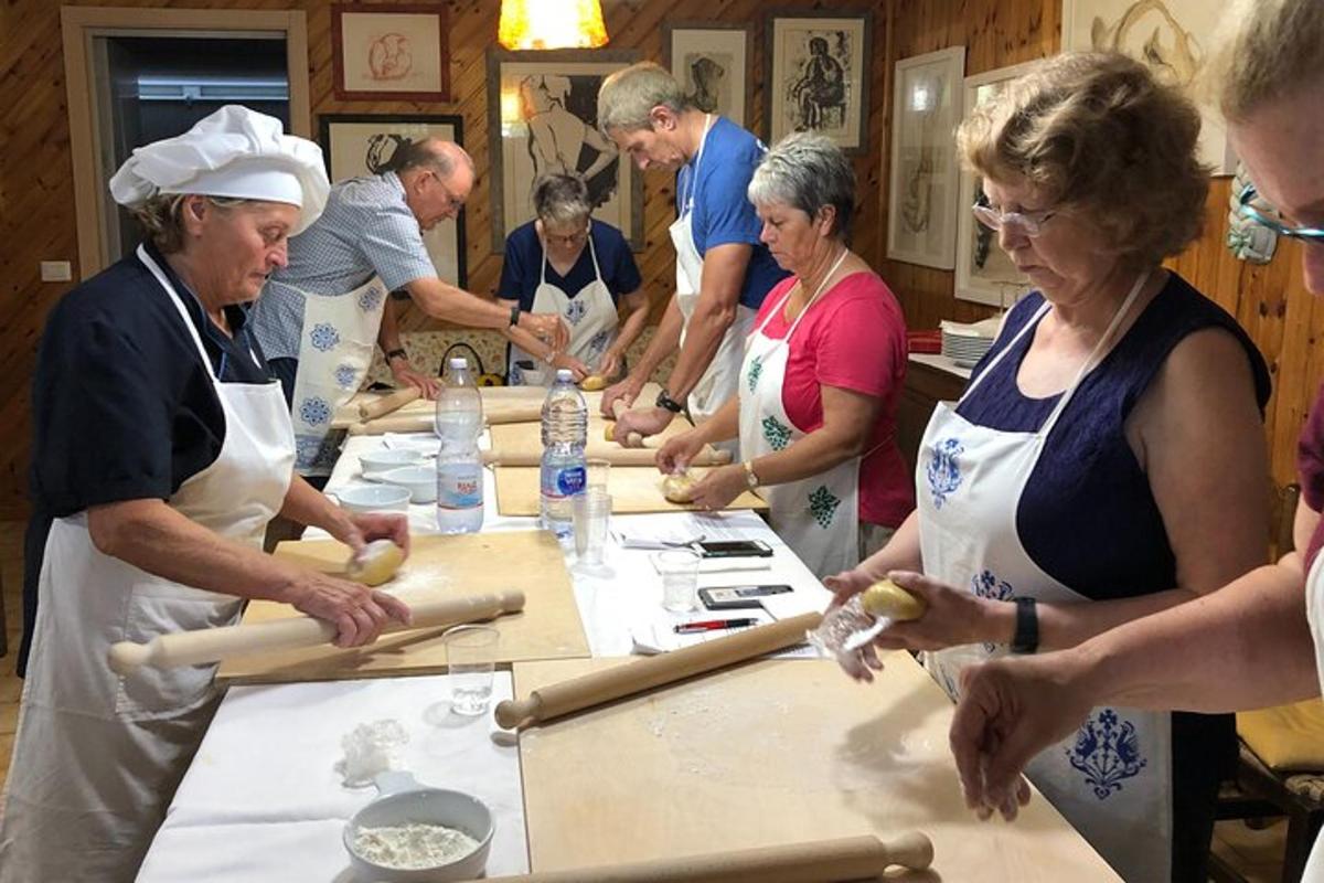 a group of people standing around a table making dough