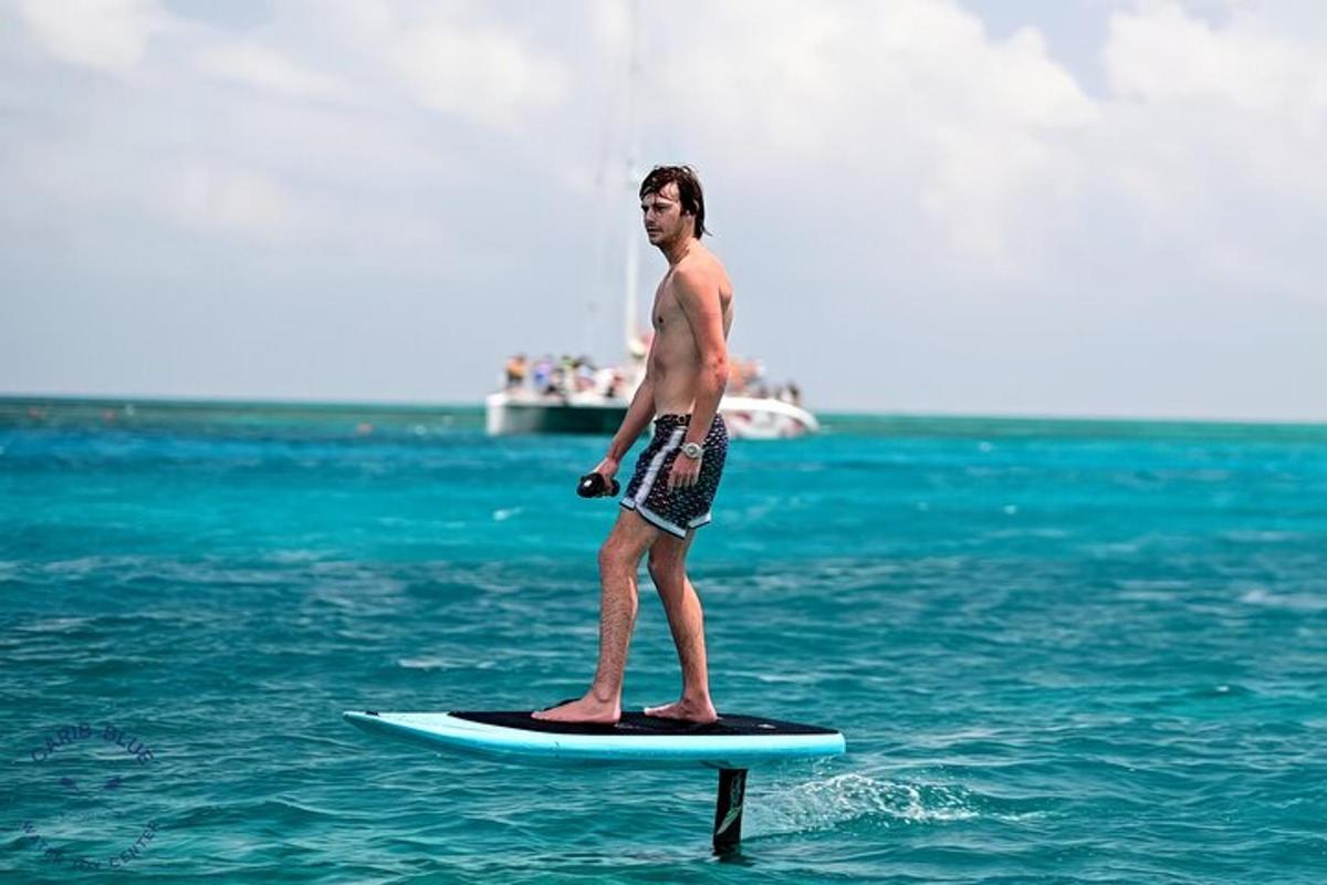 moški, ki stoji na deski za surfanje v oceanu