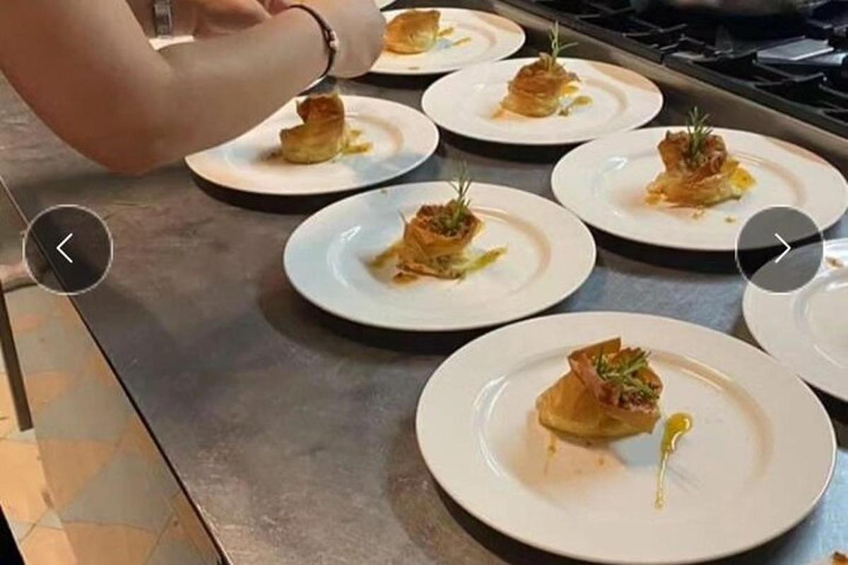 sebuah meja dengan pinggan putih berisi makanan di atasnya