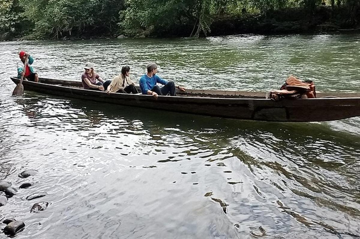 un gruppo di persone sedute su una barca su un fiume