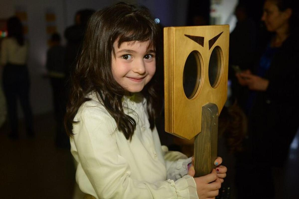 ein kleines Mädchen hält ein großes Holzschild