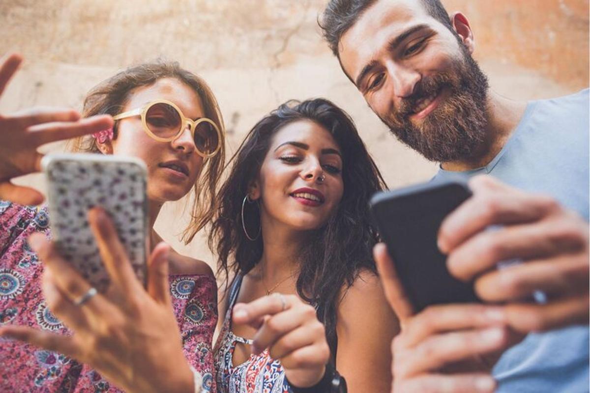 skupina lidí, kteří se dívají do svých mobilních telefonů