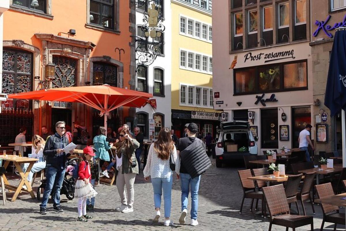 grupp inimesi, kes kõnnivad mööda tänavat vihmavarjuga