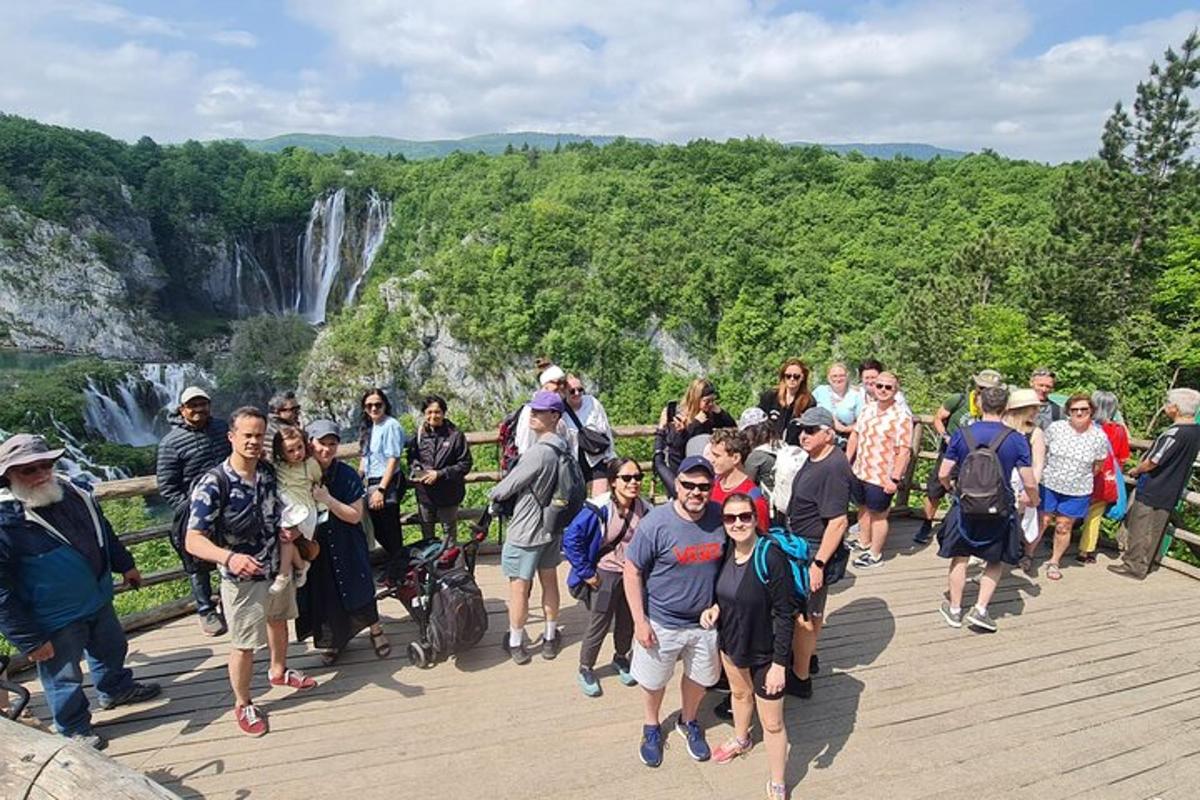 um grande grupo de pessoas caminhando em uma ponte com uma cachoeira