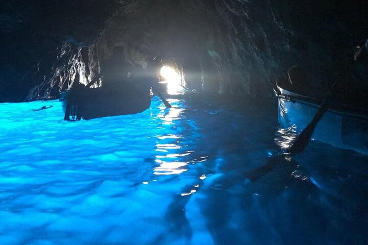 Una cueva con un barco en el agua por la noche.