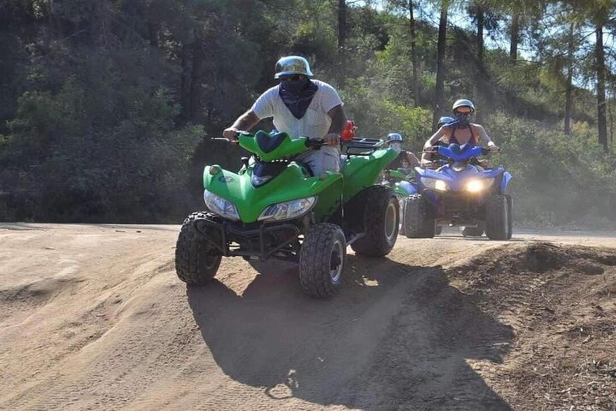 due persone che guidano un quad su una strada sterrata